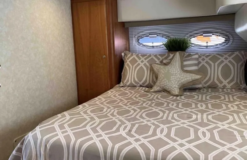 Slide: The Image of The image shows a cozy bedroom in a 1997 Silverton 372 Motor Yacht. - 14