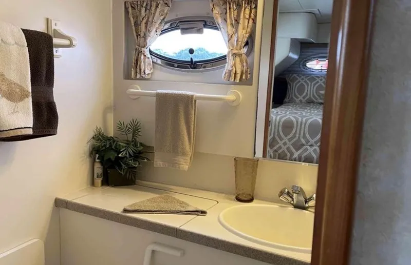 Slide: The Image of The image shows a bathroom in a 1997 Silverton 372 Motor Yacht with a sink and window. - 16