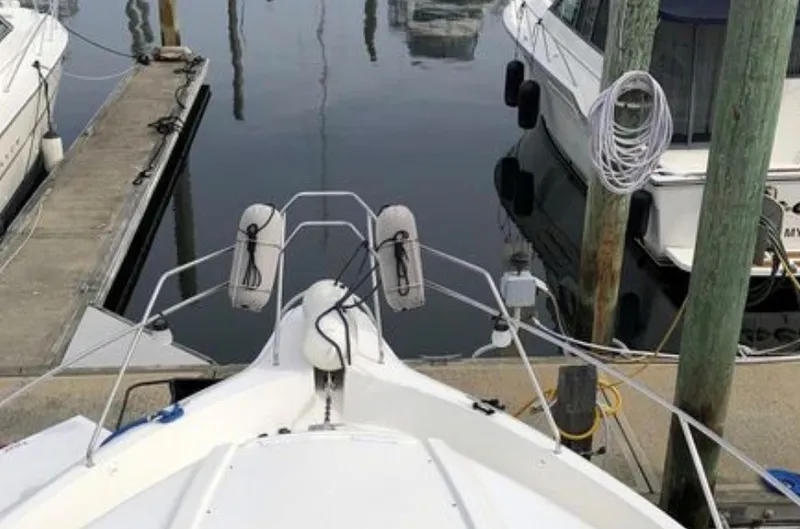 Slide: The Image of Bow view of a 1997 Silverton 372 Motor Yacht, docked in a calm marina. - 26
