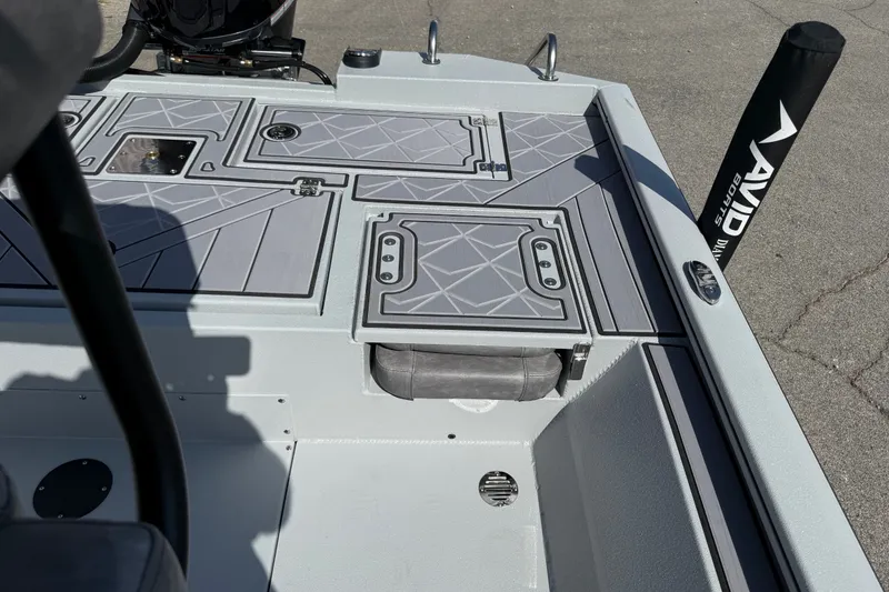 Slide: The Image of 2027 Avid 23 Mag boat deck with storage compartments and Avid branding. - 22