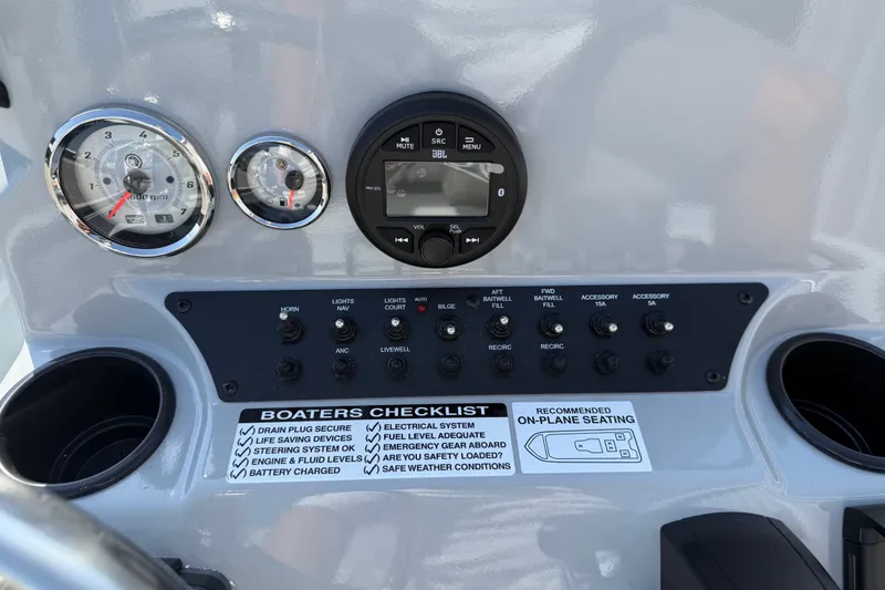 Slide: The Image of Dashboard of 2027 Avid 23 Mag boat with gauges, controls, and checklist. - 18