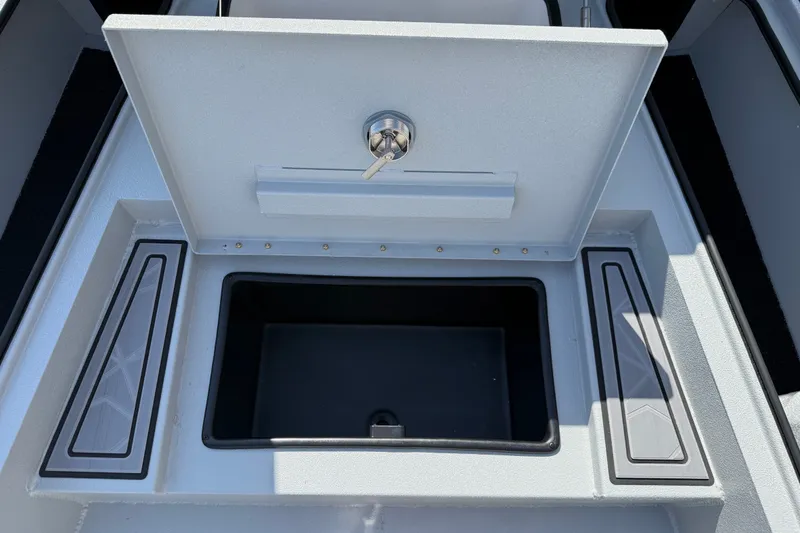 Slide: The Image of Open storage compartment on 2027 Avid 23 Mag boat, featuring secure lock and sleek design. - 10