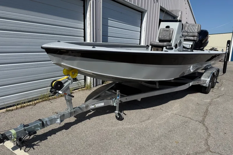 Slide: The Image of Avid 23 Mag 2027 boat on trailer, parked outside a metal building. - 6