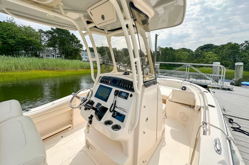 Slide: The Image of 2022 Grady-White Fisherman 216 boat interior at dock, featuring helm and seating. - 14