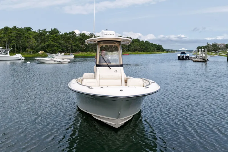 Slide: The Image of 2022 Grady-White Fisherman 216 boat on calm water, surrounded by lush greenery. - 2