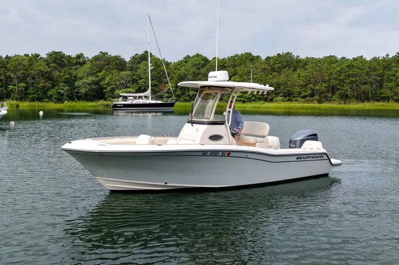 Slide: The Image of 2022 Grady-White Fisherman 216 boat on calm water with forested background. - 3