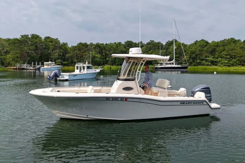 Slide: The Image of 2022 Grady-White Fisherman 216 boat on calm water with trees in the background. - 4