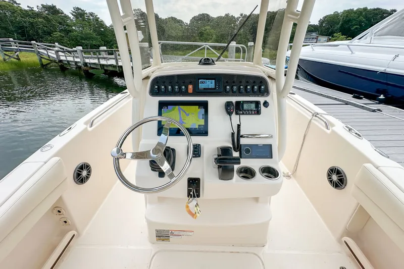 Slide: The Image of 2022 Grady-White Fisherman 216 boat dashboard with steering wheel and navigation controls. - 10
