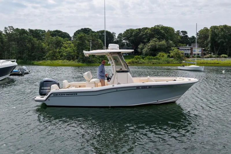 Slide: The Image of 2022 Grady-White Fisherman 216 boat on calm water, surrounded by lush greenery. - 44