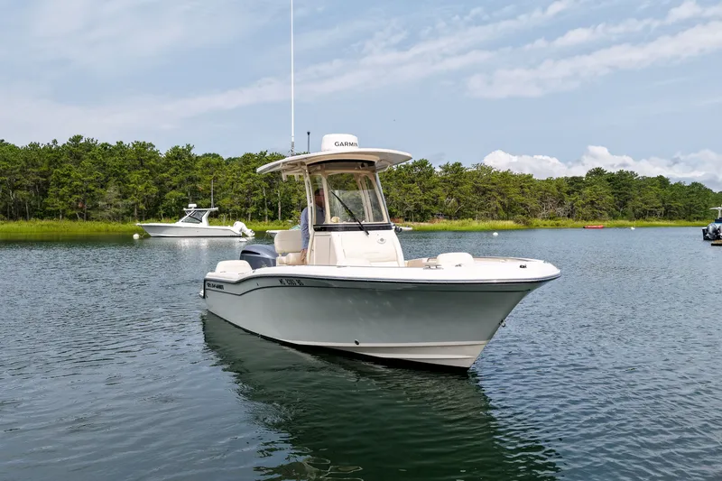 Slide: The Image of 2022 Grady-White Fisherman 216 boat on calm water with forested shoreline. - 42