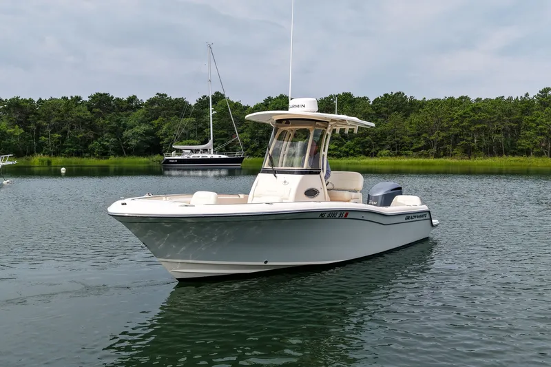 Slide: The Image of 2022 Grady-White Fisherman 216 boat on calm water, surrounded by lush greenery. - 6