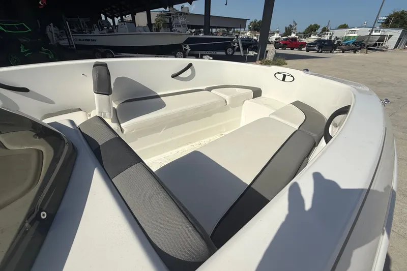 Slide: The Image of 2025 Tahoe T16 boat interior with cushioned seating in a marina setting. - 17