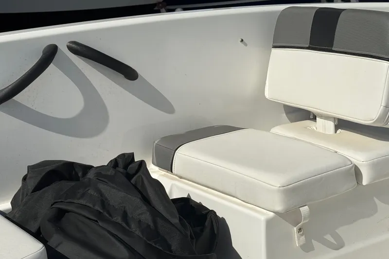 Slide: The Image of 2025 Tahoe T16 boat interior with white cushioned seating and black bag. - 15