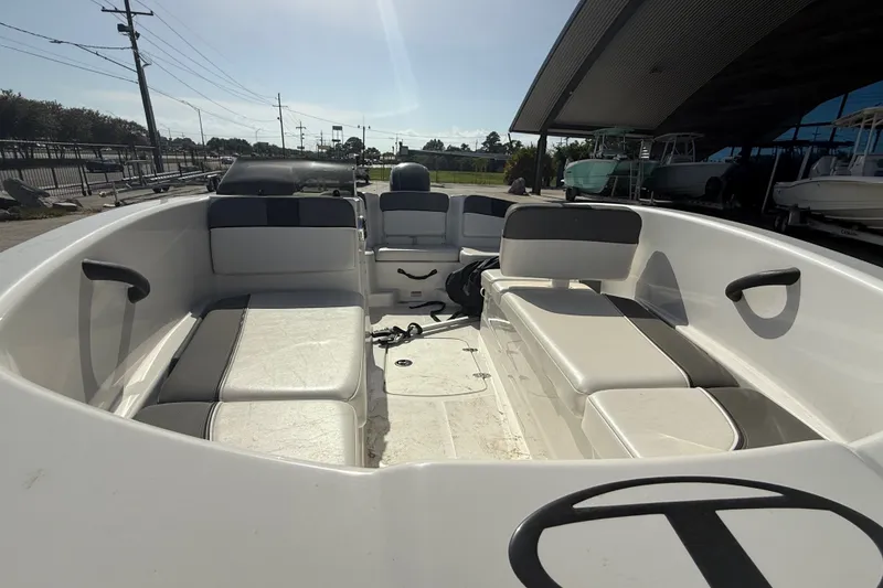 Slide: The Image of 2025 Tahoe T16 boat interior with seating, docked outdoors under sunlight. - 18