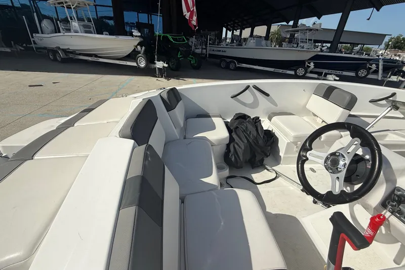 Slide: The Image of Interior of a 2025 Tahoe T16 boat with seating and steering wheel. - 16