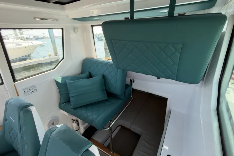 Slide: The Image of Interior of 2023 Axopar 28 Cabin with teal seating and modern design. - 20