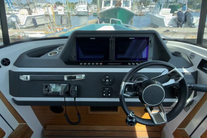 Slide: The Image of 2023 Axopar 28 Cabin helm with dual screens and modern steering wheel. - 26