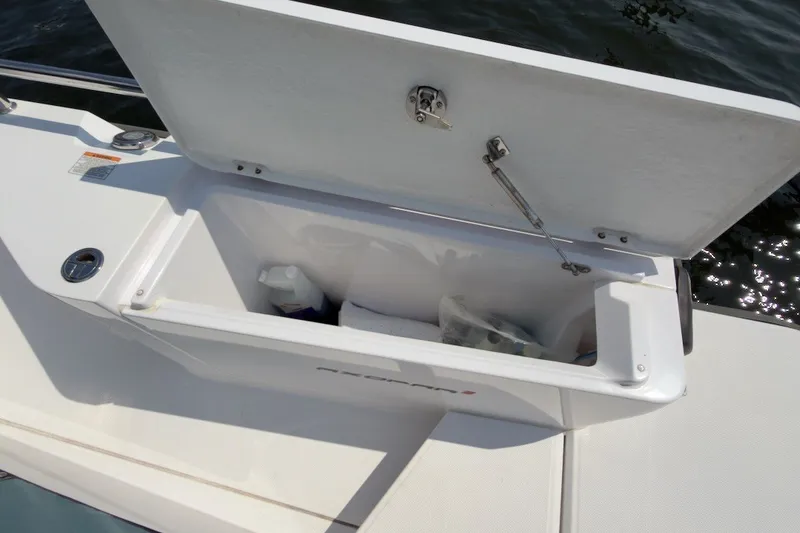 Slide: The Image of Open storage compartment on 2023 Axopar 28 Cabin boat, showing interior contents. - 42