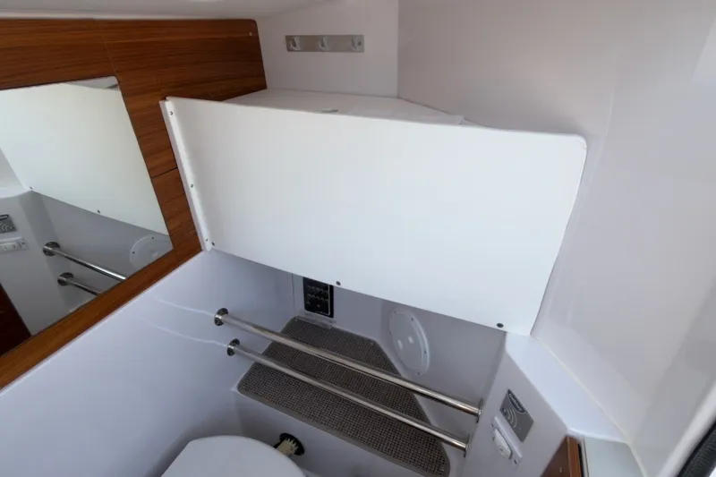 Slide: The Image of 2023 Axopar 28 Cabin interior bathroom with modern fixtures and wooden accents. - 36
