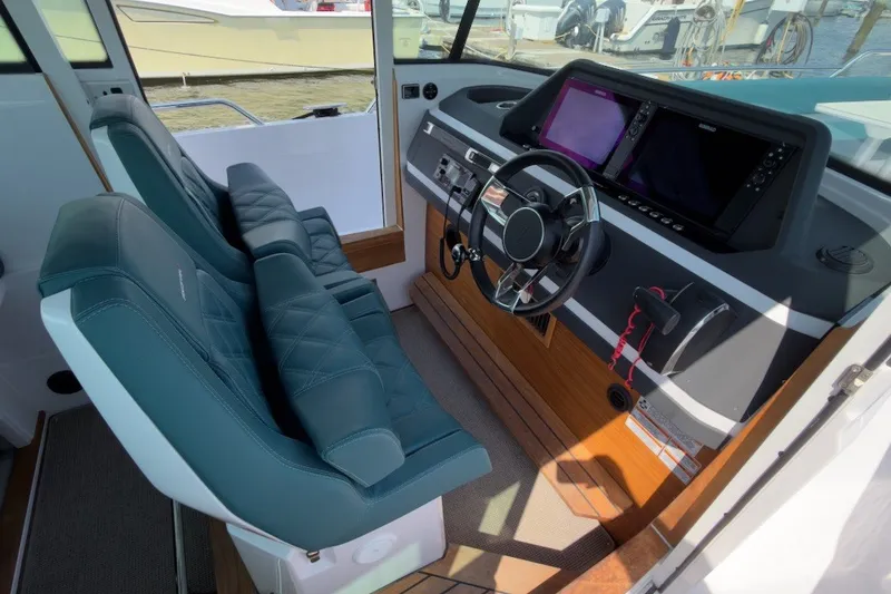 Slide: The Image of Interior of 2023 Axopar 28 Cabin boat with modern dashboard and seating. - 14