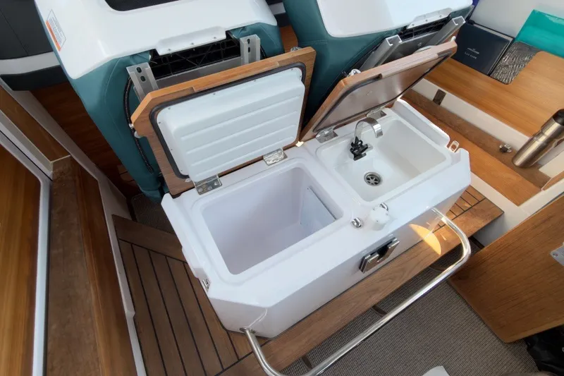 Slide: The Image of Interior of 2023 Axopar 28 Cabin featuring a compact sink and storage area. - 18