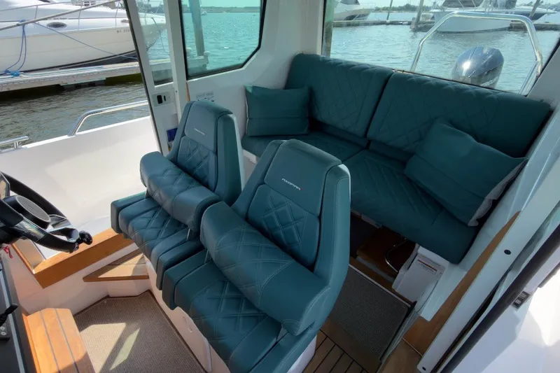 Slide: The Image of Interior of 2023 Axopar 28 Cabin boat with luxurious seating and waterfront view. - 15