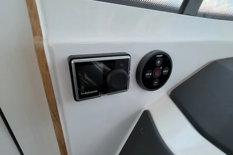 Slide: The Image of Control panel in 2023 Axopar 28 Cabin boat, featuring Webasto and Fusion systems. - 30