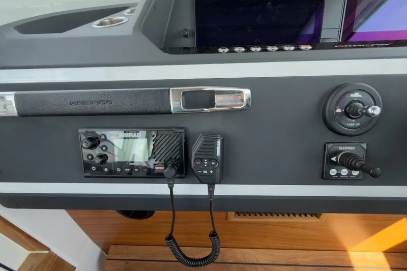 Slide: The Image of Control panel of 2023 Axopar 28 Cabin boat with Simrad electronics and navigation controls. - 28