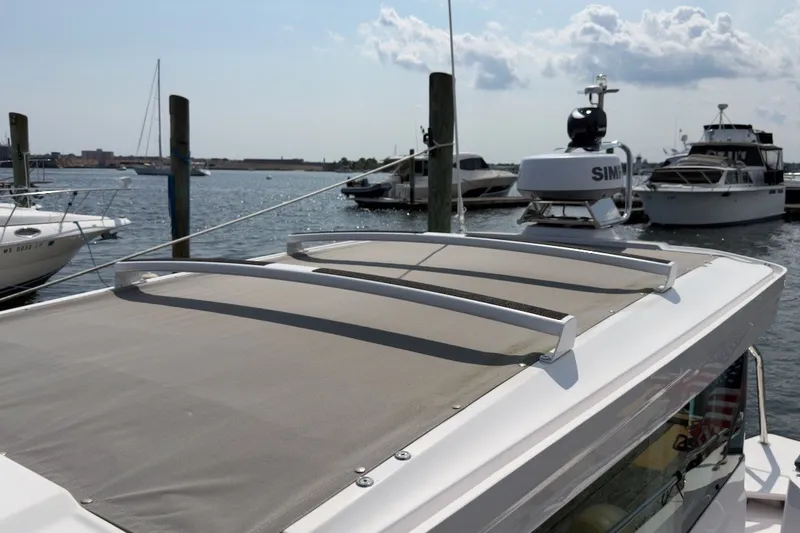 Slide: The Image of 2023 Axopar 28 Cabin boat docked, showcasing roof and radar equipment. - 45