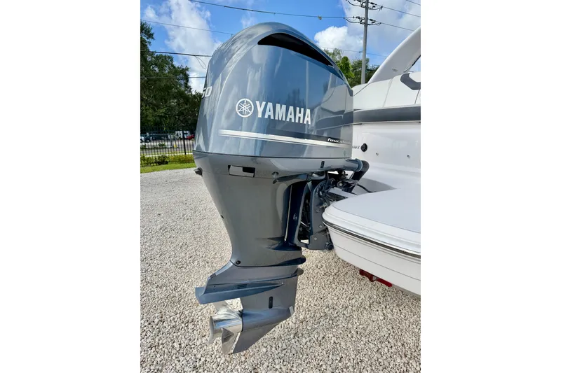 Slide: The Image of 2019 Regal 23 OBX with Yamaha outboard motor, parked on gravel under a blue sky. - 28