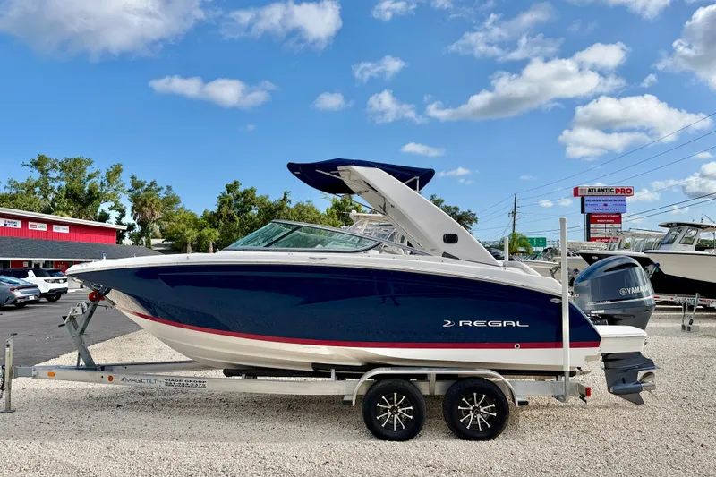 The Image of 2019 Regal 23 OBX boat on trailer under blue sky. - 0