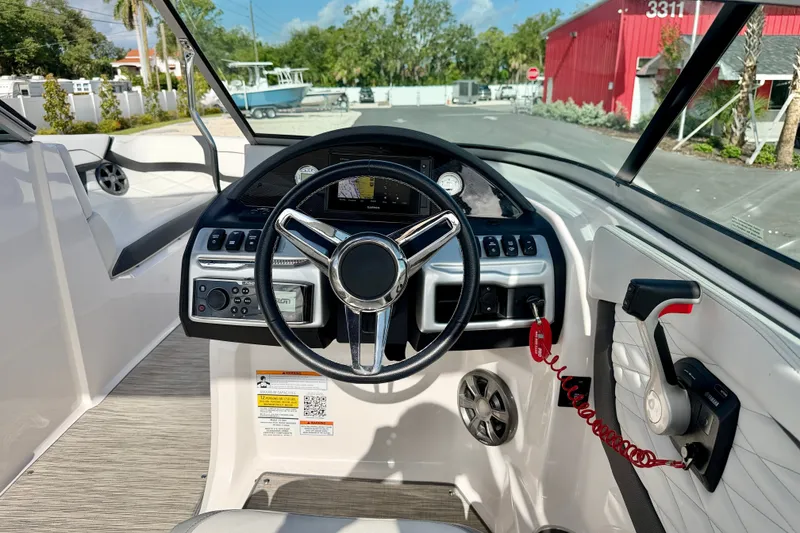 Slide: The Image of 2019 Regal 23 OBX boat cockpit with steering wheel and control panel. - 13