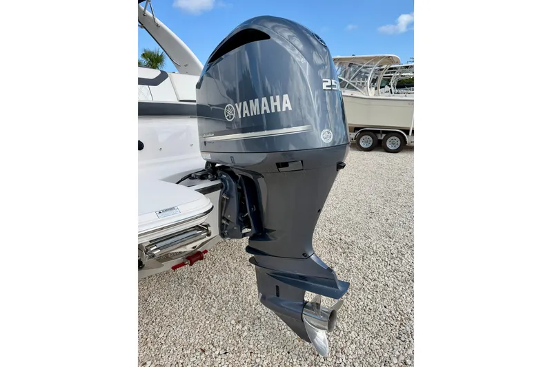 Slide: The Image of 2019 Regal 23 OBX with Yamaha outboard motor, parked on gravel. - 30