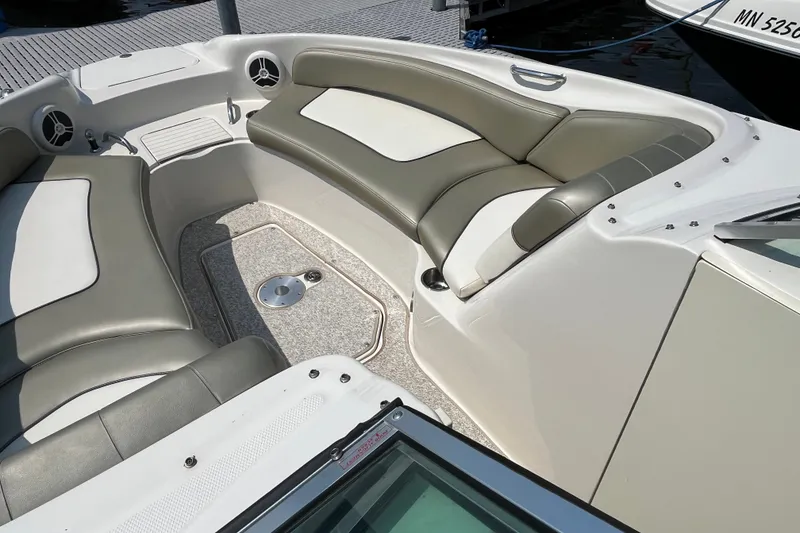 Slide: The Image of 2007 Sea Ray 240 Sundeck interior with cushioned seating and cup holders. - 14