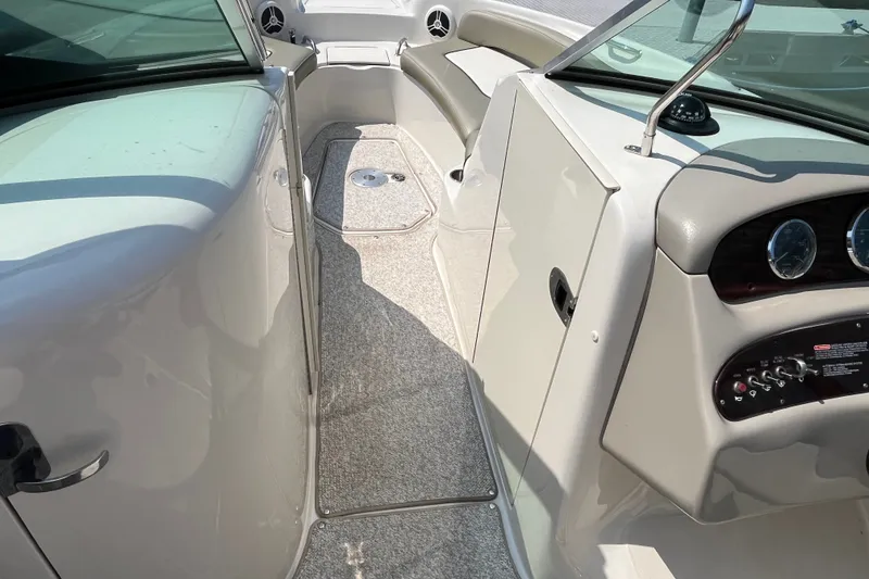 Slide: The Image of 2007 Sea Ray 240 Sundeck interior with dashboard, seating, and carpeted flooring. - 15
