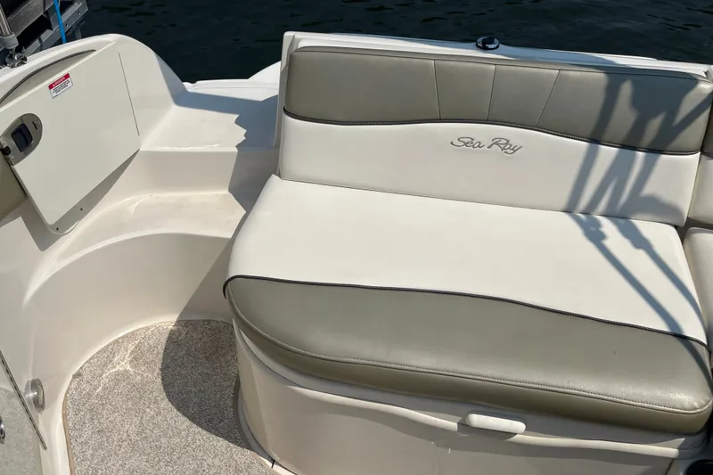 Slide: The Image of 2007 Sea Ray 240 Sundeck boat seating area with white and gray upholstery. - 27