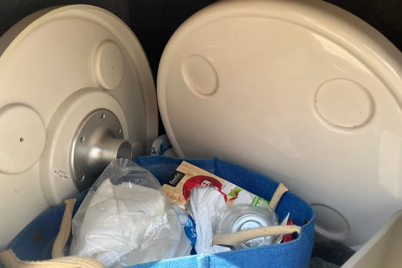Slide: The Image of Storage compartment of a 2007 Sea Ray 240 Sundeck with items and table tops. - 24