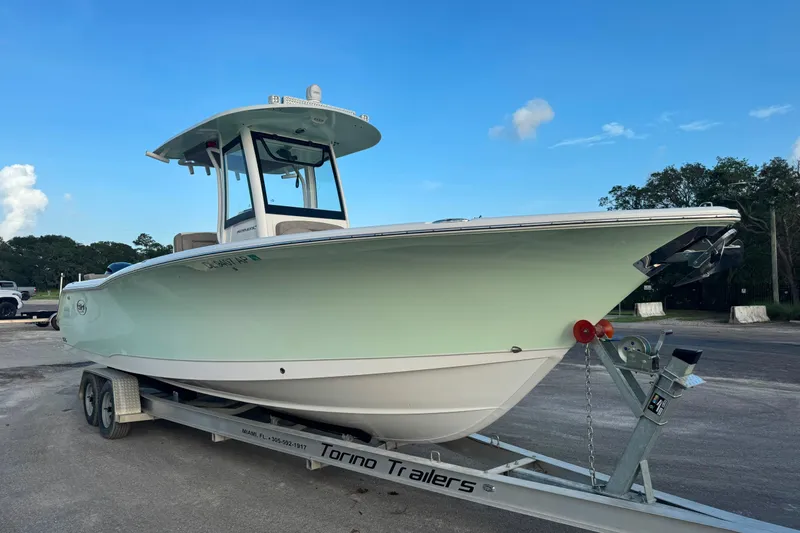 Slide: The Image of 2020 Sea Hunt Ultra 275SE boat on trailer under clear blue sky. - 0