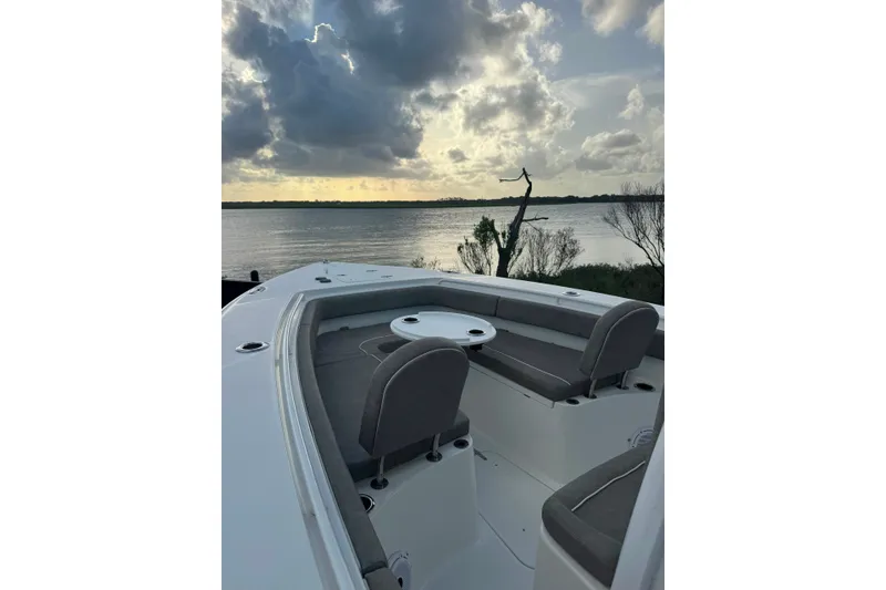 Slide: The Image of 2020 Sea Hunt Ultra 275SE boat interior with seating, overlooking serene water and cloudy sky. - 35