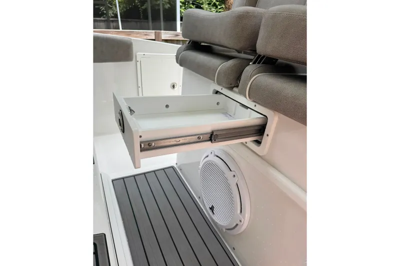 Slide: The Image of 2020 Sea Hunt Ultra 275SE boat interior with open storage drawer and speaker. - 49