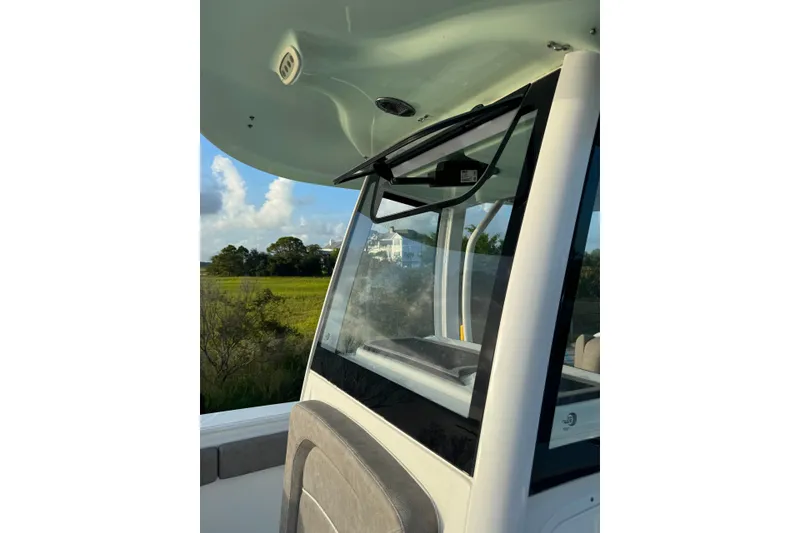 Slide: The Image of 2020 Sea Hunt Ultra 275SE boat interior with windshield and console, scenic background. - 20