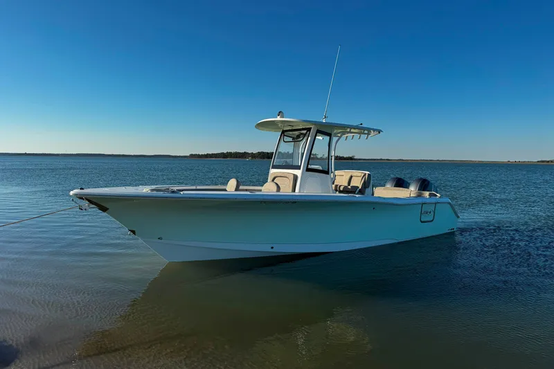 Slide: The Image of 2020 Sea Hunt Ultra 275SE boat on calm water under clear blue sky. - 9