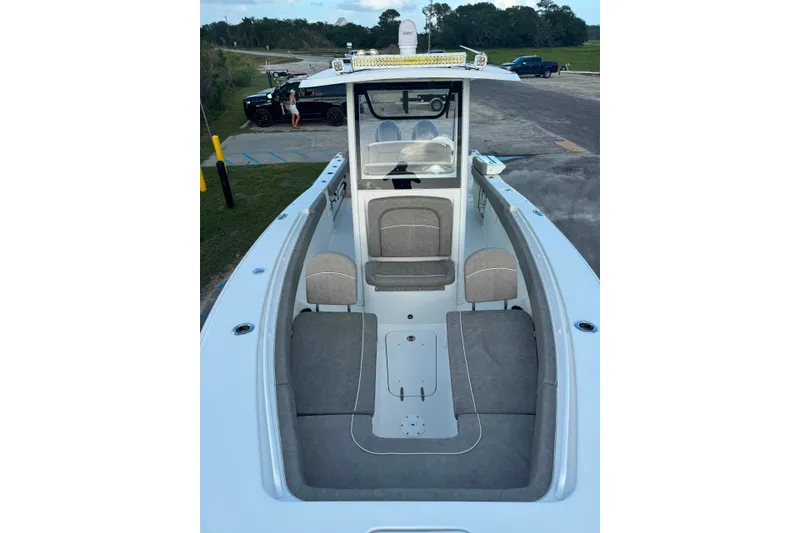 Slide: The Image of 2020 Sea Hunt Ultra 275SE boat interior with seating and console, parked on a trailer. - 15