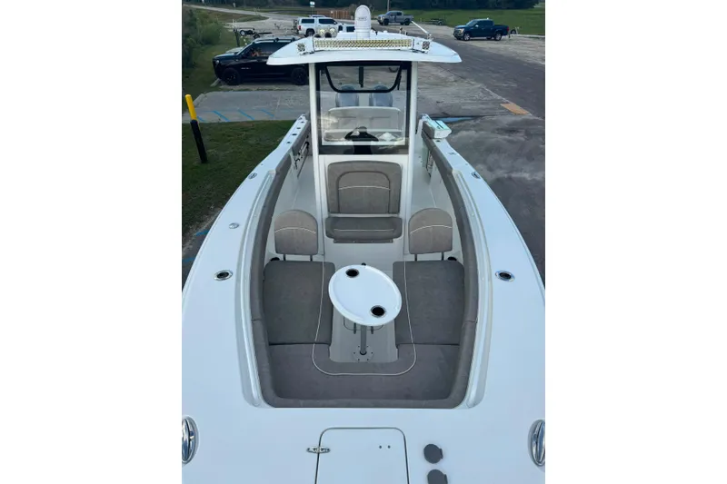 Slide: The Image of 2020 Sea Hunt Ultra 275SE boat interior with seating and table, parked on a trailer. - 16