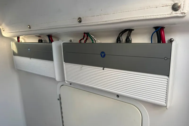 Slide: The Image of Electrical components inside a 2020 Sea Hunt Ultra 275SE boat, featuring wiring and panels. - 25