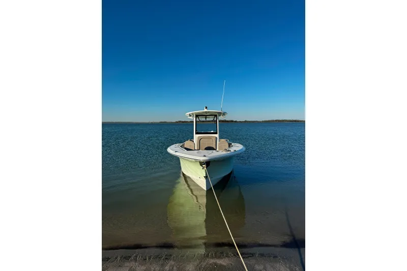 Slide: The Image of A 2020 Sea Hunt Ultra 275SE boat is moored at the shore of a calm water body. - 8