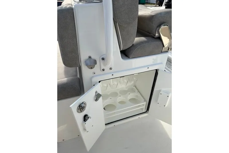 Slide: The Image of Open storage compartment on 2020 Sea Hunt Ultra 275SE boat with cup holders. - 54
