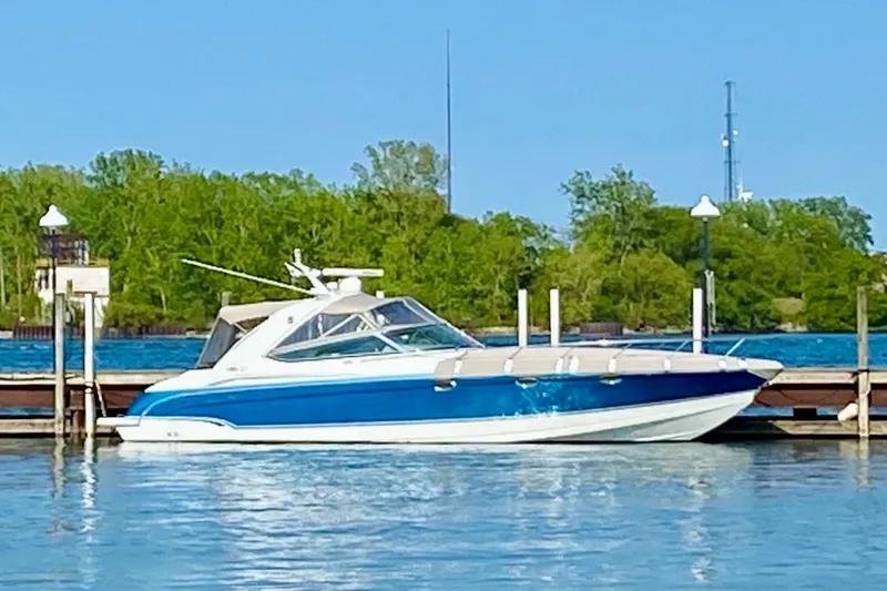 Slide: The Image of 2006 Formula 400 Super Sport boat docked on a sunny day with lush greenery. - 2