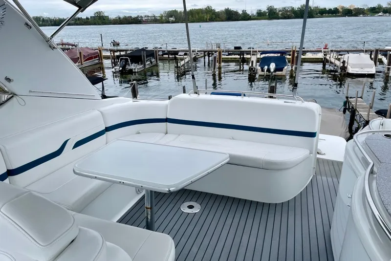 Slide: The Image of 2006 Formula 400 Super Sport boat interior with seating and table by the water. - 17