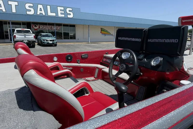 Slide: The Image of 2022 Phoenix 921 Elite boat with red interior and dual Humminbird displays at dealership. - 18